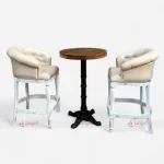 Elegant white bar chairs with cast iron legs paired with a round solid wood table.