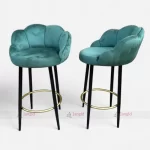 Two Teal velvet bar stools with elegant metal legs with golden footrest ring, perfect for adding a touch of luxury to any room