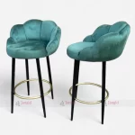Two Teal velvet bar stools with elegant metal legs with golden footrest ring, perfect for adding a touch of luxury to any room
