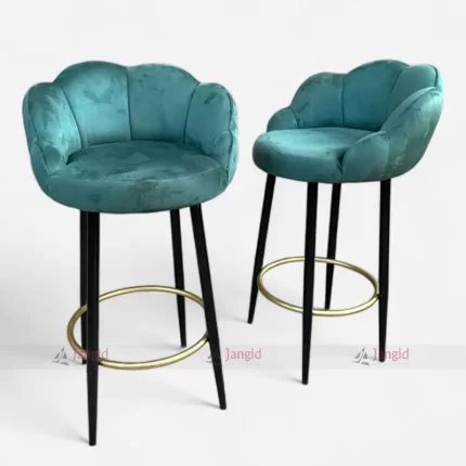 Two Teal velvet bar stools with elegant metal legs with golden footrest ring, perfect for adding a touch of luxury to any room