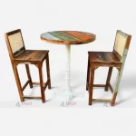 Reclaimed wood bar table and two chairs featuring cane work and circular table top.
