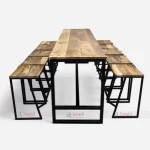 A vintage bar furniture set with a metal frame, featuring a long bar table and ten stools with a rough mango wood top and metal base.