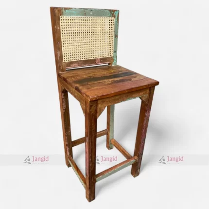 A colorful bar chair made from reclaimed upcycled wood, featuring and a vintage-style cane back.