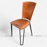 A Buff Leather French Bistro Colt Side Chair featuring a brown seat and sleek black legs, exuding elegance and comfort.