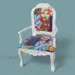 A white chair featuring vibrant patchwork upholstery, crafted from sturdy mango wood, ideal for stylish hotel room interiors.
