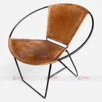 An industrial vintage chair featuring a leather seat and round metal frame, perfect for enhancing comfort and style in any setting.