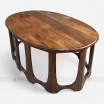 A stylish oval-shaped wooden coffee table made of mango wood, perfect for hotels and lounges, showcasing unique patterns.